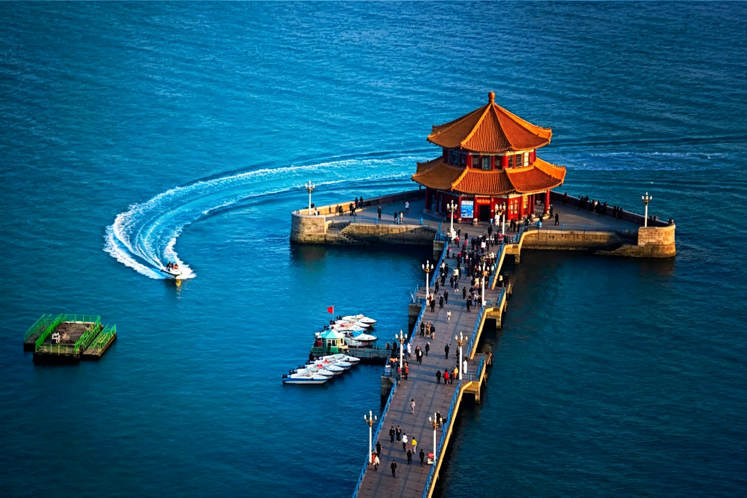 Zhanqiao Pier stretching into Qingdao Bay — the iconic Huilan Pavilion and wheeling seagulls against the blue sea